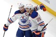 Edmonton Oilers' Darnell Nurse (25) celebrates with Connor McDavid after scoring the first of two third period goals in an NHL hockey game against the Pittsburgh Penguins in Pittsburgh on March 10, 2024. The Oilers won 4-0.