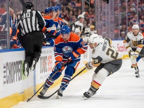 EDMONTON, CANADA - APRIL 10: Sam Carrick #39 of the Edmonton Oilers and Alec Martinez #23 of the Vegas Golden Knights battle for the puck along the boards at Rogers Place on April 10, 2024, in Edmonton, Alberta, Canada.