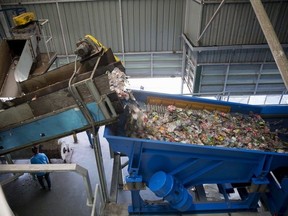 Polyethylene terephthalate (PET) bottles pass through a sorting machine at a recycling facility.