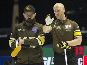 Team Manitoba-Carruthers skip Brad Jacobs and third Reid Carruthers stand back of the rings during Draw 2 against team Manitoba-Dunstone. Curling Canada/ Michael Burns Photo