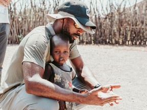 Edmonton Elks CFL receiver Eugene Lewis is shown holding a child in this handout image provided by World Vision Canada. Like many, Lewis had seen the commercials that ask for donations to help less fortunate children in Africa but nothing prepared him to see their plight up close and personal. This offseason, the Edmonton Elks receiver served as an ambassador with World Vision Canada and spent time on a mission to Africa.