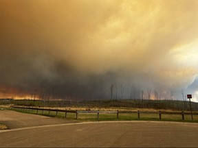 This handout image courtesy of Kosar shows smoke and flames from the fire in Fort McMurray on May 14, 2024 as residents from the area of Abasand Heights evacuate the area. Evacuations have been ordered in oil-producing Fort McMurray, Alberta on May 14. Authorities have been bracing for another possibly devastating wildfire season, after Canada's worst ever last year that saw flames burning from coast to coast and charring more than 15 million hectares (37 million acres) of land.