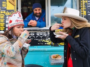 Mumbai Bites food truck owner Reshan Singh watches as Calgary Stampede Princess Brooke Fielding and First Nations Princess Margaret Holloway try his Momos on a Stick on Wednesday May 8, 2024. The Calgary Stampede was showcasing some of the new midway food coming at this year's Stampede.