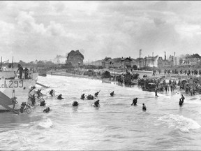 This photo, taken on June 6, 1944, shows Canadian soldiers from 9th Brigade landing at Juno Beach in Bernieres-sur-Mer as Allied forces stormed Normandy beaches in north-western France on D-Day. Imperial War Museum.