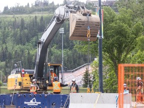 Crews and machinery work at the site of a major water feeder main break along 16 Avenue N.W. in Calgary on Sunday, June 16, 2024. As of 3 p.m. that day, the pit was being cleared of equipment to prepare for backfill.