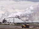Canadian oil and gas companies facing a federally imposed emissions cap will cut their production rather than invest in emissions-reducing carbon capture and storage technology, a new report by Deloitte says. A dump truck works near an oilsands extraction facility near Fort McMurray.