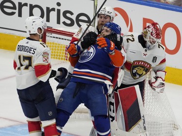 Edmonton Oilers Connor McDavid (97) is grabbed from behind by Florida Panthers Sam Bennett (9) during third period game 6 action of the NHL Stanley Cup final on Friday, June 21, 2024 in Edmonton.   Greg Southam-Postmedia