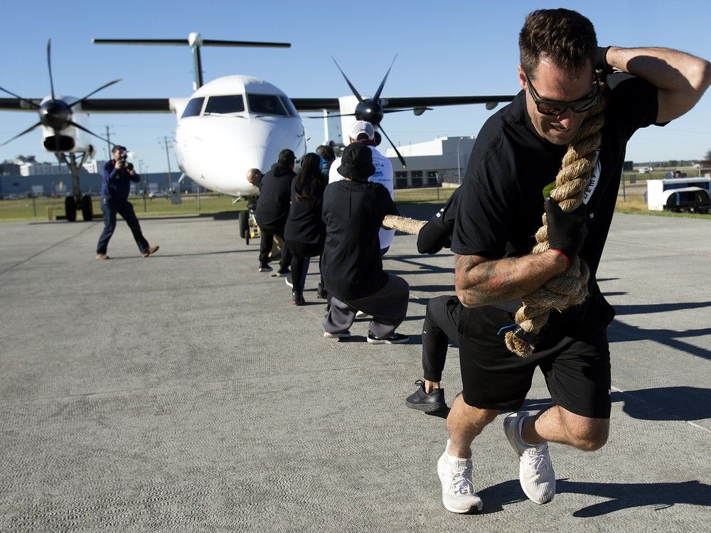 A team pulls a 67,000-lb. aircraft 100 metres during the Hope Air's Annual Plane Pull, Haul for Hope event at the Edmonton International Airport on Monday, Sept. 16, 2024. The event aimed to raise funds and awareness for the Hope Air charity which provides free travel support for those in financial need seeking medical treatment far from home.