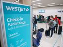 WestJet customers check in at the Calgary International Airport.