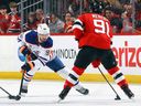 Edmonton Oilers' Jake Walman #96 defends Dawson Mercer #91 of the New Jersey Devils's Dawson Mercer #91 on March 13, 2025 at the Prudential Center in Newark, New Jersey on Stage 1 in New Jersey.