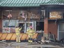 Firefighters look for hot spots after putting out a fire at the strip mall at 34 Avenue and 34 Edmonton Street and 92 Street on Tuesday, April 8, 2025.