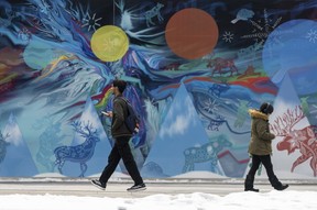 A man walked past the mural behind the Edmonton sign in front of the town hall on Monday, March 31, 2025.