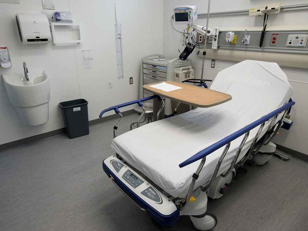 A doctor looking thoughtfully at a busy hospital hallway, symbolizing the strain on healthcare systems.