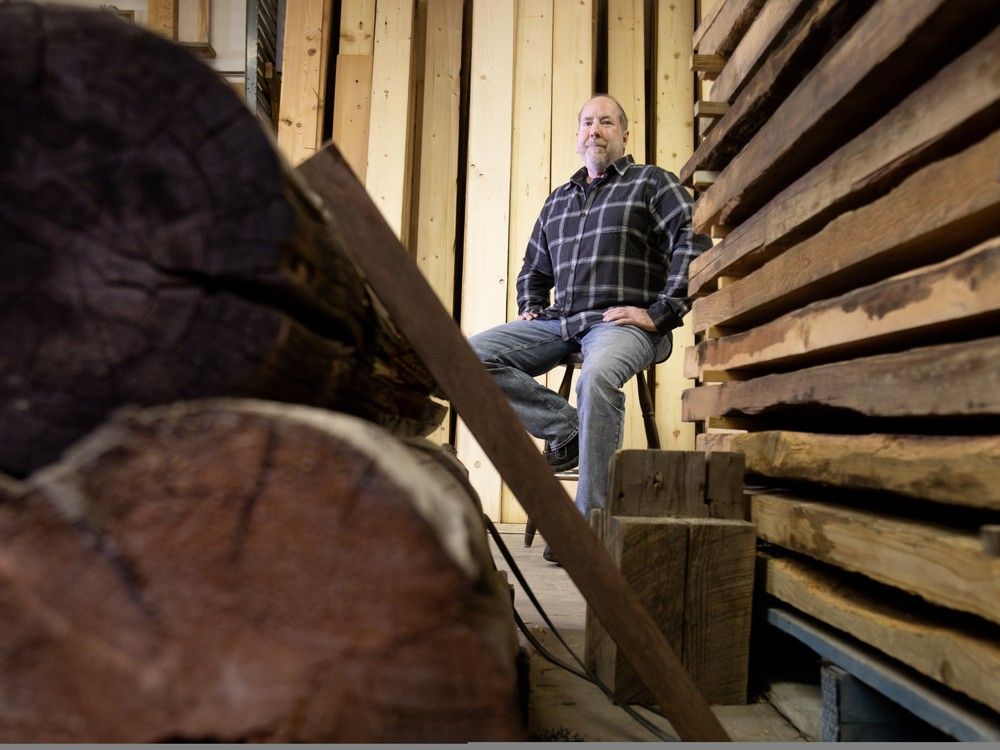  Backroads Reclamation co-owner Kirk Bentham is framed by lumber reclaimed from Fort Edmonton Park, left, and the Northlands horse stables, right, while in his workshop east of Edmonton on Friday, Jan. 2, 2026. Backroads Reclamation is working to take reclaimed wood from the city’s old buildings and turn it into a consistent construction lumber supply.