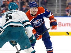 The Edmonton Oilers' Zach Hyman (18) battles the San Jose Sharks' Vincent Desharnais (5)