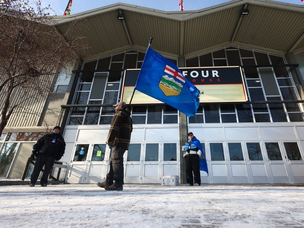 Volunteers held flags as they welcomed those coming to sign an Alberta separatism petition at the Big Four building in Calgary on Jan. 26.