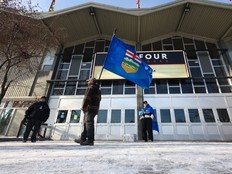 Volunteers held flags as they welcomed those coming to sign an Alberta separatism petition at the Big Four building in Calgary on Jan. 26.