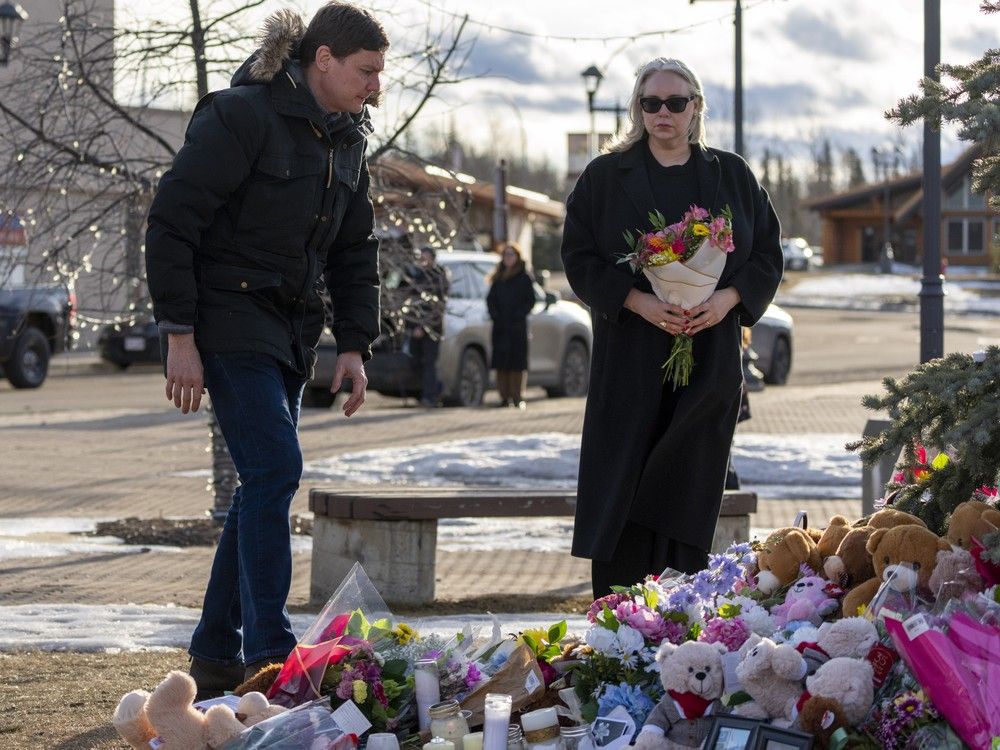 B.C. Premier David Eby and B.C. Public Safety Minister Nina Krieger on Thursday, Feb. 12, 2026, put flowers at a memorial near the Tumbler Ridge Secondary School where a mass shooting took place on Tuesday.