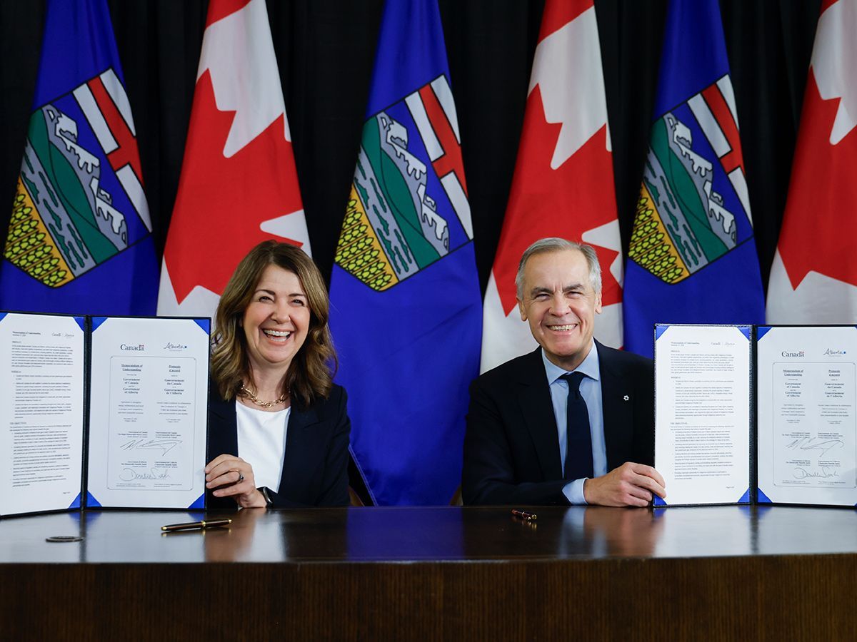Alberta Premier Danielle Smith and Prime Minister Mark Carney display the memorandum of understanding they signed in Calgary, on Nov. 27, 2025.