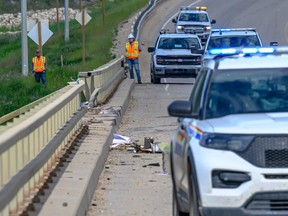 Police set up where a 300 ton crane truck went through the railing of Wapiti Bridge and into the river below, five kilometres south of Grande Prairie on June 16.