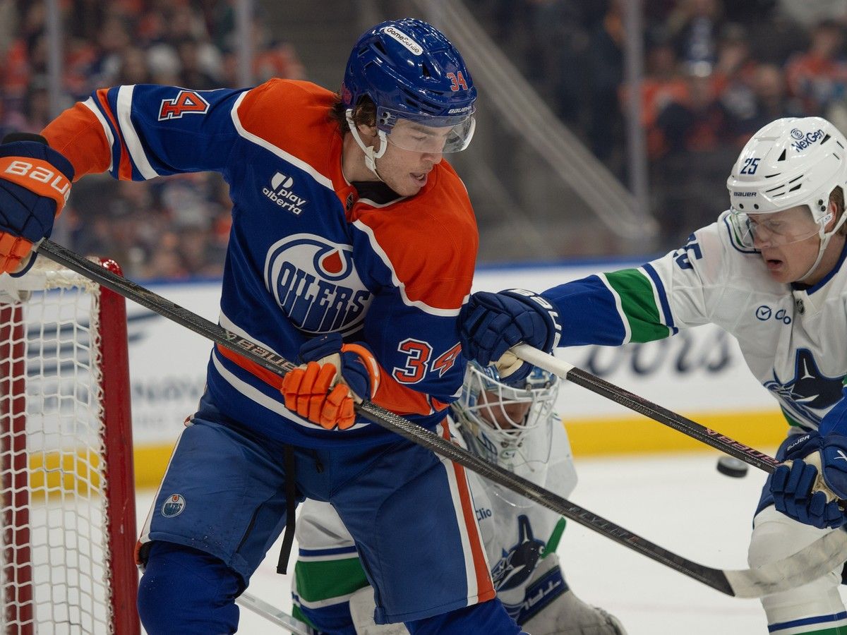 Colton Dach (34) of the Edmonton Oilers, tangles with Elias Pettersson (25) of the Vancouver Canucks at Rogers Place on Thursday, April 16, 2026.