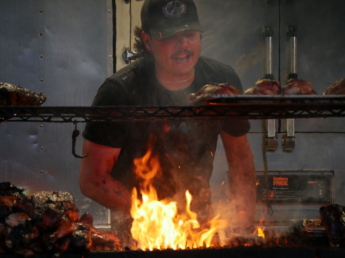 A vendor grills ribs behind a stash of trophies and awards at Ribfest in Fort McMurray, Alta. Sept. 6, 2026. PHOTO BY ITORO UMANAH/FORT MCMURRAY TODAY