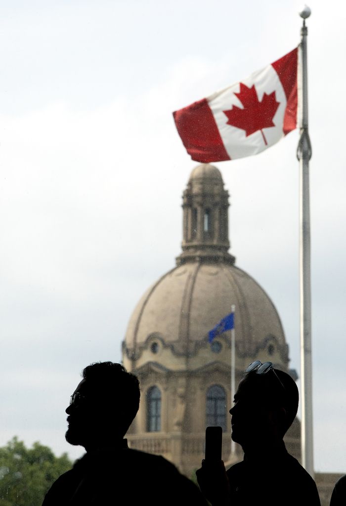 A Canadian Flag and the dome of the Alberta Legislature are visible in the background in Edmonton,