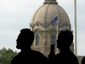 A Canadian Flag and the dome of the Alberta Legislature are visible in the background in Edmonton,