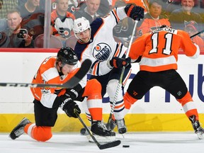 Anton Slepyshev #58 of the Edmonton Oilers tries to get to the puck past Nolan Patrick #19 and Travis Konecny #11 of the Philadelphia Flyers at the Wells Fargo Center on October 21, 2017 in Philadelphia, Pennsylvania.