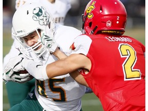 Calgary Dinos Deane Leonard tackles UofA Golden Bears receiver Nathan Rowe during Football action at McMahon stadium in Calgary on Saturday, October 28, 2017.