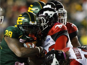 Calgary Stampeders' Mike Klassen (90), Alex Singleton (49), Brandon Smith (28), Jameer Thurman (56) stop Edmonton Eskimos' C.J. Gable (39) during second half CFL action in Edmonton on October 28, 2017.