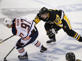 Pittsburgh Penguins' Sidney Crosby (87) tries to slow down Edmonton Oilers' Connor McDavid (97) in the third period of an NHL hockey game in Pittsburgh, Tuesday, Oct. 24, 2017. The Penguins won 2-1 in overtime.