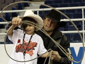 Shane McCann, 7, and CFR competitor Stetson Vest take part in Rodeo Magic at Northlands Coliseum, in Edmonton Wednesday Nov. 8, 2017. Over 150 children with special needs were given the rodeo experience with the help of Canadian Finals Rodeo competitors.