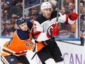 Zack Kassian #44 of the Edmonton Oilers hits John Moore #2 of the New Jersey Devils at Rogers Place in Edmonton on Friday, Nov. 3, 2017.