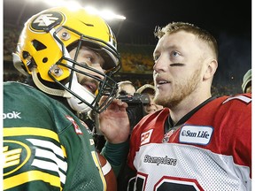 Edmonton Eskimos quarterback Mike Reilly chats with quarterback Bo Levi Mitchell of the Calgary Stampeders after beating the Stamps 31-45 during the CFL's West Final at Commonwealth Stadium in Edmonton, Alta., on Sunday November 22, 2015.
