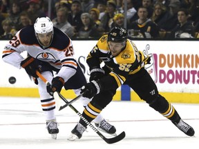 Edmonton Oilers center Leon Draisaitl (29) and Boston Bruins center Sean Kuraly (52) vie for the puck during the second period of an NHL hockey game in Boston, Sunday, Nov. 26, 2017.