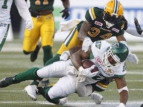 Saskatchewan Roughriders' Cameron Marshall (32) is tackled by Edmonton Eskimos' Garry Peters (34) during first half CFL action in Edmonton, Alta., on Friday August 25, 2017.