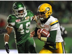 Edmonton Eskimos quarterback Mike Reilly runs the ball as Saskatchewan Roughriders' Jeff Knox Jr. chases during first half CFL football action at Mosaic Stadium in Regina on Saturday, November 4, 2017.