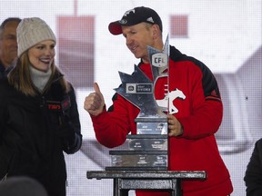 Calgary Stampeders head coach Dave Dickenson stands with the trophy following the CFL West Final football game against the Edmonton Eskimos in Calgary, Sunday, Nov. 19, 2017.