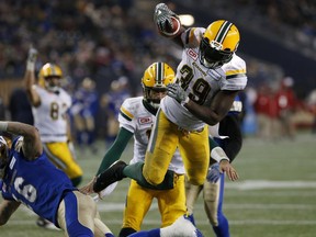 Edmonton Eskimos running back C.J. Gable leaps over Winnipeg Blue Bombers' Taylor Loffler for the winning touchdown during CFL playoff action in Winnipeg on Nov. 12, 2017.