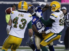 Winnipeg Blue Bombers' Clarence Denmark (89) can't make the catch as he's covered by Edmonton Eskimos' Forrest Hightower (35) and Neil King (43) during second half CFL western semifinal action in Winnipeg on November 12, 2017.