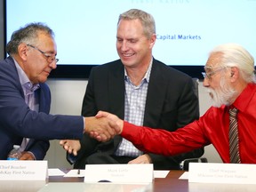 Fort McKay First Nation Chief Jim Boucher, left, shakes hands with Mikisew Cree First Nation Chief Archie Waquan as Mark Little, Suncor's president of upstream operations, looks on.