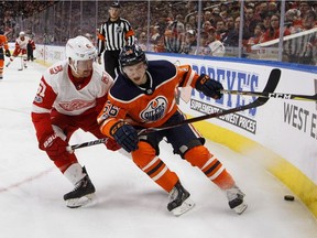 Detroit Red Wings' Xavier Ouellet and Edmonton Oilers' Kailer Yamamoto (56) vie for the puck during NHL action in Edmonton on Nov. 5, 2017.