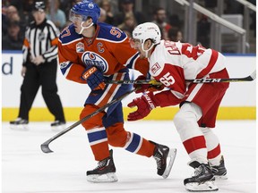 Edmonton's Connor McDavid (97) is held by Detroit's Danny DeKeyser (65) during the second period of a NHL game between the Edmonton Oilers and the Detroit Red Wings at Rogers Place in Edmonton on Saturday, March 4, 2017.