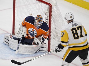 Edmonton Oilers goalie Cam Talbot (33) stops the puck as Pittsburgh Penguins Sidney Crosby (87) watches during second period NHL action on Wednesday November 1, 2017, in Edmonton.