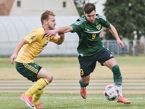 University of Alberta striker Nikko Cuglietta, right, attempts to get by University of Northern British Columbia midfielder Brett Bobier in Canada West play at Foote Field in Edmonton on Oct. 28, 2017.