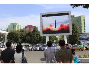 People watch a launching of a Hwasong-12 strategic ballistic rocket aired on a public TV screen at the Pyongyang Train Station in Pyongyang, North Korea, Saturday, Sept. 16, 2017. (AP Photo/Jon Chol Jin)