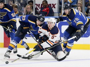 Edmonton Oilers centre Connor McDavid, middle, competes for the puck against St. Louis Blues right wing Dmitrij Jaskin, left, and centre Oskar Sundqvist during NHL action on Nov. 21, 2017, at the Scottrade Center in St. Louis.