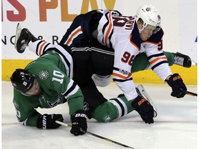 Dallas Stars center Martin Hanzal (10) and Edmonton Oilers right wing Jesse Puljujarvi (98) fall to the ice during the third period of an NHL hockey game in Dallas, Saturday, Nov. 18, 2017. The Stars won 6-3.