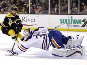 Edmonton Oilers goalie Cam Talbot (33) dives to make a save as Boston Bruins defenseman Colin Miller (6) closes in during the second period of an NHL hockey game, Thursday, Jan. 5, 2017, in Boston.